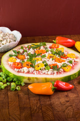 Vegetarian watermelon pizza with crumbled blue cheese, bell peppers and parsley.