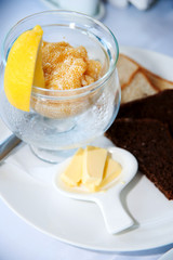 pike caviar in a glass plate on table with lemon butter and bread