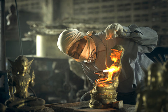 Man welding a traditional buddah sculpture, Thailand