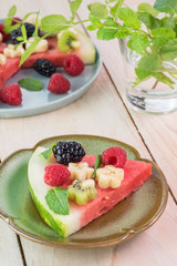 Piece of fruit watermelon pizza with fresh berries, banana, kiwi