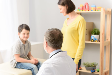 Obraz premium Młody chłopak ze swoim pediatrą i matką