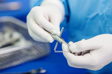 Close-up of scrub nurse taking medical instruments for operation