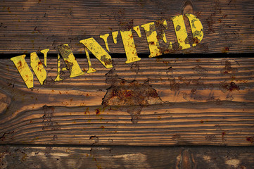 WANTED - yellow rusty iron sign on the vintage brown wooden wall - western style