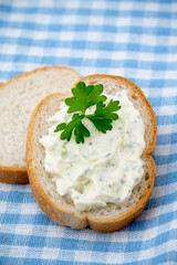 Bread with fresh cream cheese and red caviar on table.