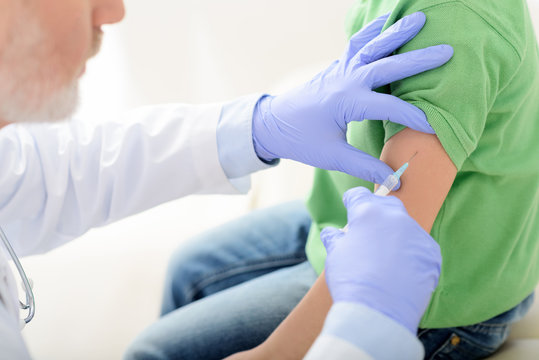 Doctor pediatrician injecting vaccine