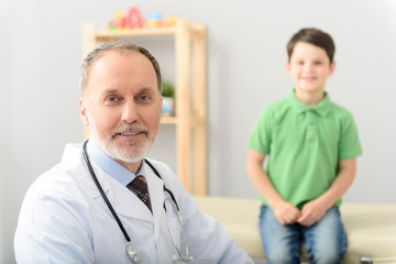Pediatrician doctor examining small boy