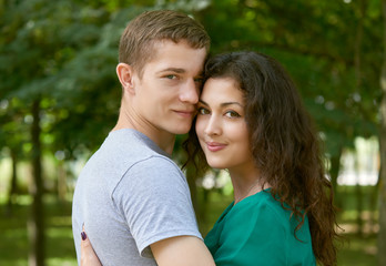Romantic couple posing in city park, summer season, young people backside