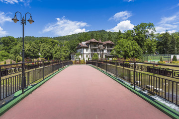 Fototapeta premium Promenade along a river Szczawnica village on sunny summer day, Pieniny Mountains, Poland