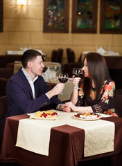Couple toasting wineglasses in a luxury restaurant