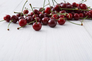 Sweet fresh cherries on white wood background