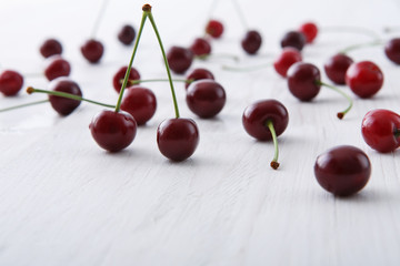 Sweet fresh cherries on white wood background