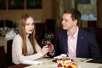 Couple toasting wineglasses in a luxury restaurant.