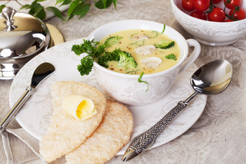 cream soup with broccoli and mushrooms still life, original cutlery, spoon, beautiful