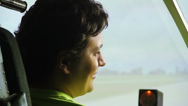 Smiling man passing flight test at airplane simulator, interesting hobby