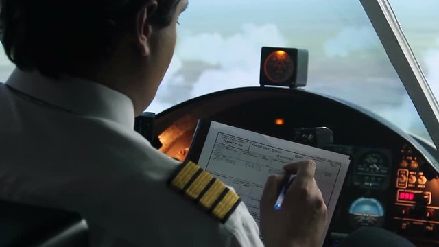 Plane captain writing down information in flight plan, autopilot, transportation