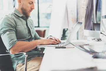 Bearded Hipster working Laptop modern Interior Design Loft Office.Man Work Coworking Studio,Use contemporary Notebook,typing keyboard.Blurred Background.Creative Business Startup Idea.Horizontal,Fil