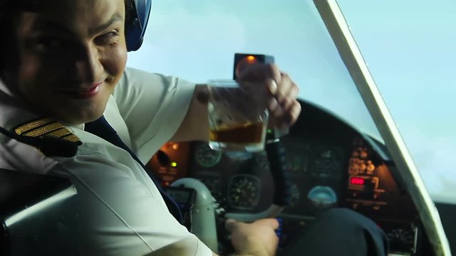 Crazy pilot drinking alcohol in cockpit and navigating plane, dangerous maniac