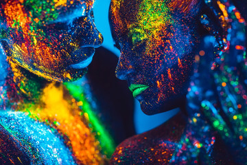 People are colored fluorescent powder. a pair of lovers dancing