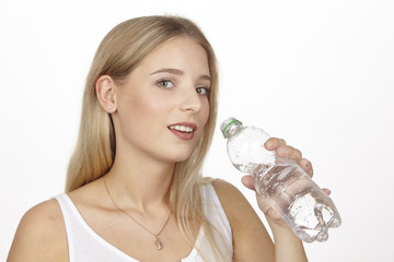 JUnge blonde Frau hält kleine Plastikflasche mit Wasser