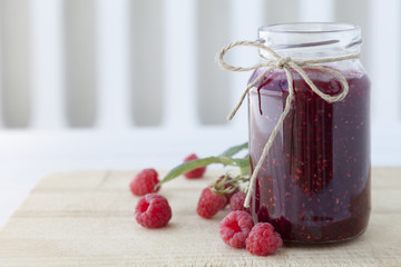 Himbeermarmelade auf einem Frühstücksbrettchen auf dem Tisch