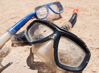 A pair of mask and snorkels on a golden sandy beach, with a beautiful shallow depth of field.