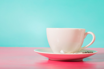 White coffee mug on bright pink and blue background