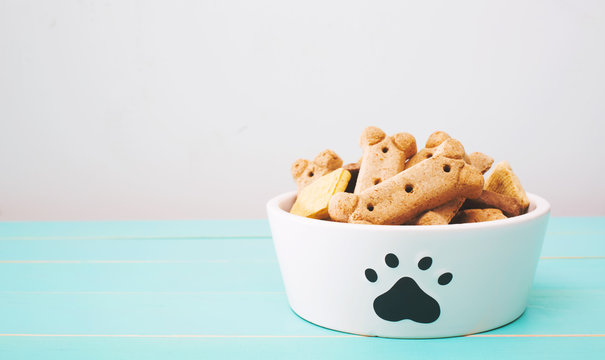 Naklejki Dog treats in a bowl on wooden table
