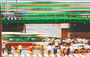 Obraz premium Motion blurred crowds crossing a busy intersection in Tokyo