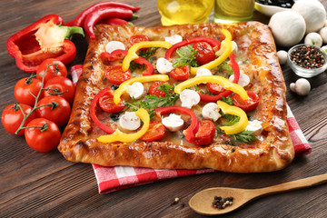 Freshly homemade pizza on wooden background