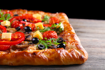 Freshly homemade pizza on wooden table closeup