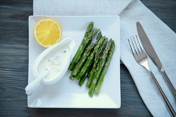 Asparagus with lemon and sauce on plate