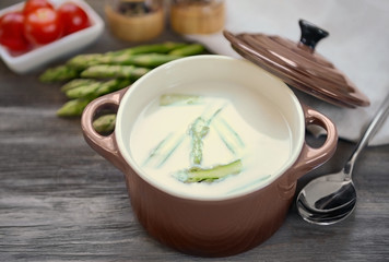 Asparagus soup on wooden table