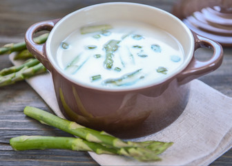 Asparagus soup on wooden table