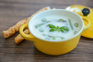 Asparagus soup with bread sticks on wooden table