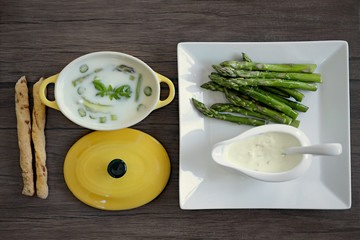 Asparagus soup with bread sticks on wooden table