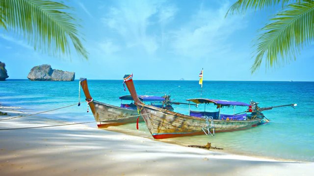 Video 1080p - Handmade, wooden boats with improvised motors and sun shelters for tourist passengers, moored to a tropical beach in Thailand.
