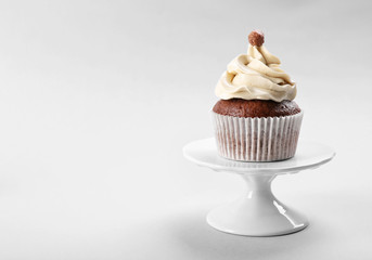 Tasty cupcake on light background