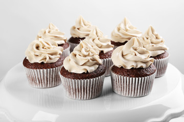 Tasty cupcakes on white stand