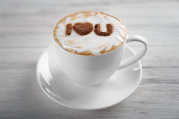 Cup of coffee with creative pattern on wooden table