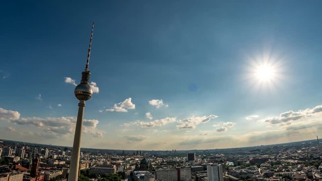 Perfect Skyline aerial of Berlin with beautiful sun and some clouds. Summer time in the late afternoon. Beautiful lens flare blue and yellow colors. Hyper lapse. Fernsehturm, TV-Tower
