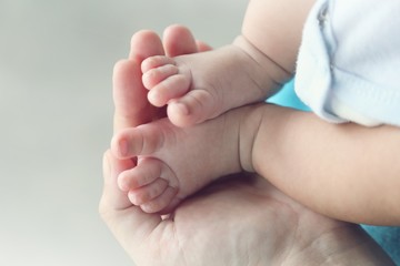Obraz na płótnie Canvas Photo of newborn baby feet and hand in soft focus