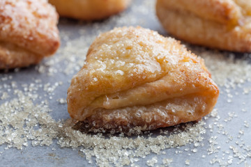 Sweet cottage cheese cookie covered in sugar crystals and honey extreme closeup