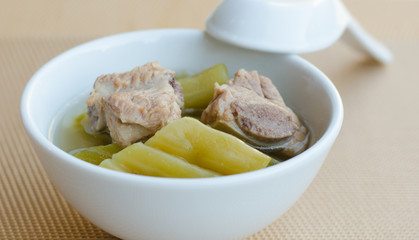 Bitter cucumber with pork rib soup in white bowl on table