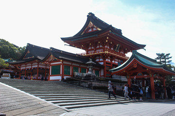 Fototapeta premium KYOTO, JAPAN- APRIL,11 2016: Many unidentified tourists viit sFushimi Inari Shrine and take a photo at Torii gate in Kyoto, Japan.