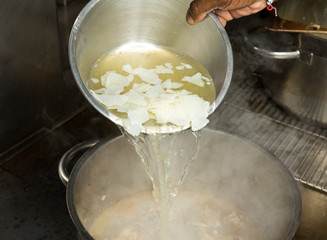 ice Cold fresh organic chicken stock being poured onto hot chicken wings.