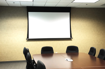 table, chairs in meeting room with projector screen