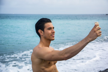 Shirtless Young Man Taking Selfie Photos at Beach