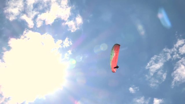 Flying Paraglider on a Background of the Sun and Beautiful Clouds