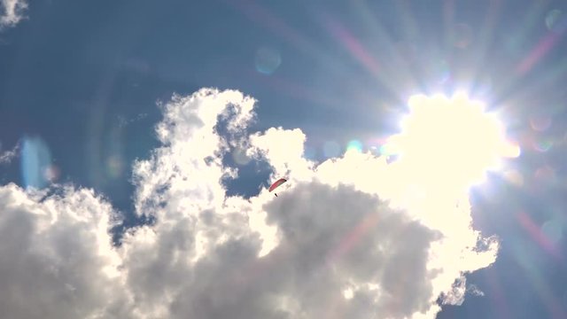 Flying Paraglider on a Background of the Sun and Beautiful Clouds