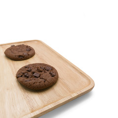 Chocolate cookies with chocolate chip on square wooden plate isolated on white background